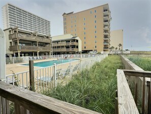 Un hotel con varias edificaciones, un área de piscina y un paseo marítimo.