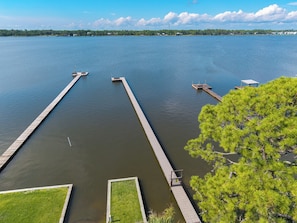 Una propiedad frente al lago con dos muelles que se adentran en sus tranquilas aguas, rodeada de vegetación.