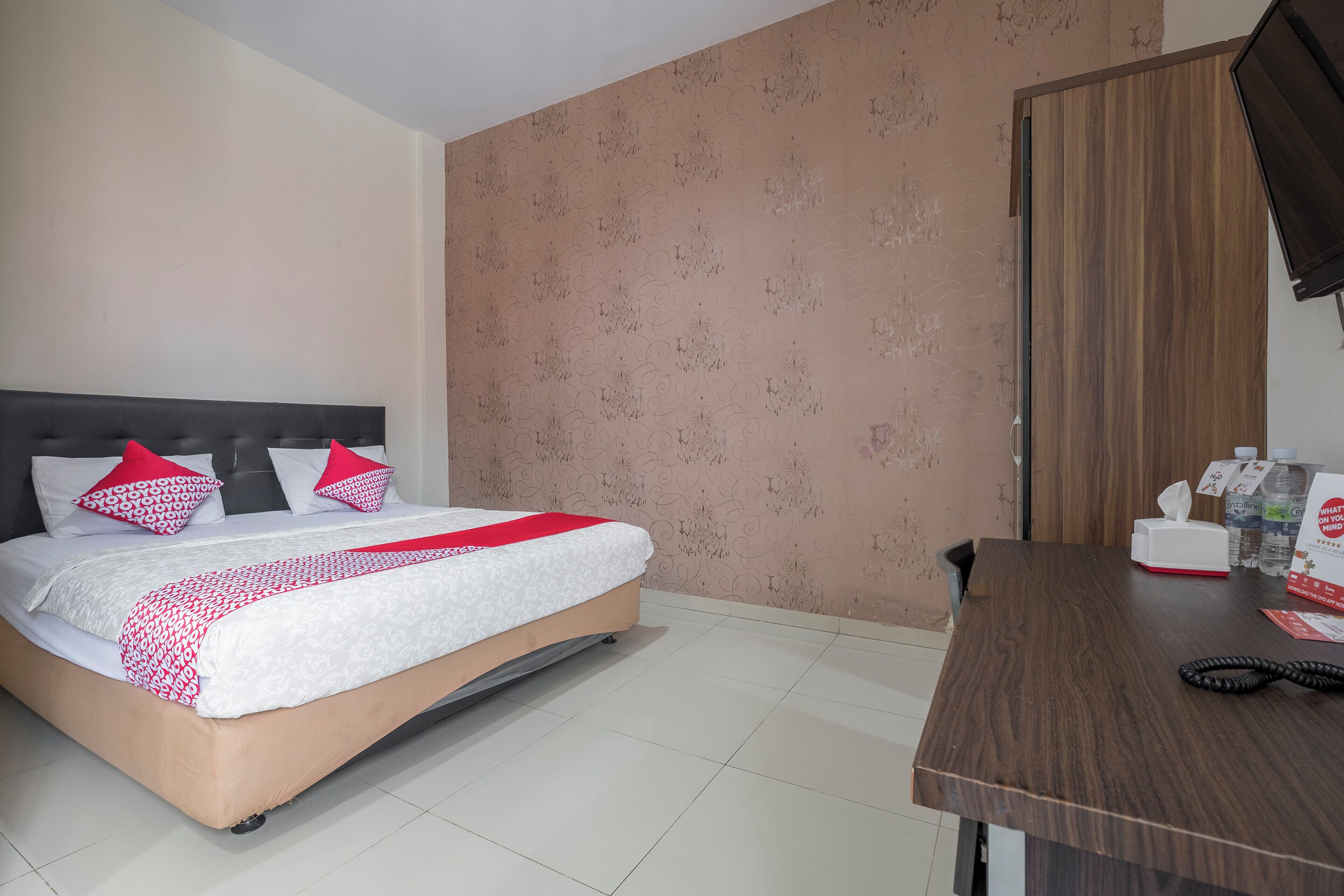 Ein Hotelzimmer mit Bett, Schreibtisch und Kleiderschrank.