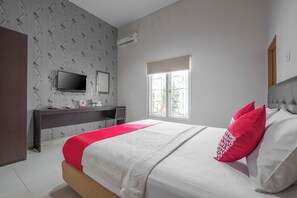 A bedroom with a bed, a desk, a TV, and a window. - Hotel O Makassar near Pantai Losari formerly Hotel Astra Novilia (Makassar)