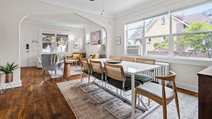 A dining area with a white table, wooden chairs, and a ceiling fan. - 5280 Oasis - Hot Tub + Walk to Sloan's Lake (Denver)