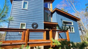 Un bâtiment à deux étages, à la façade bleue, doté d’une terrasse en bois et d’une enseigne circulaire portant une inscription.