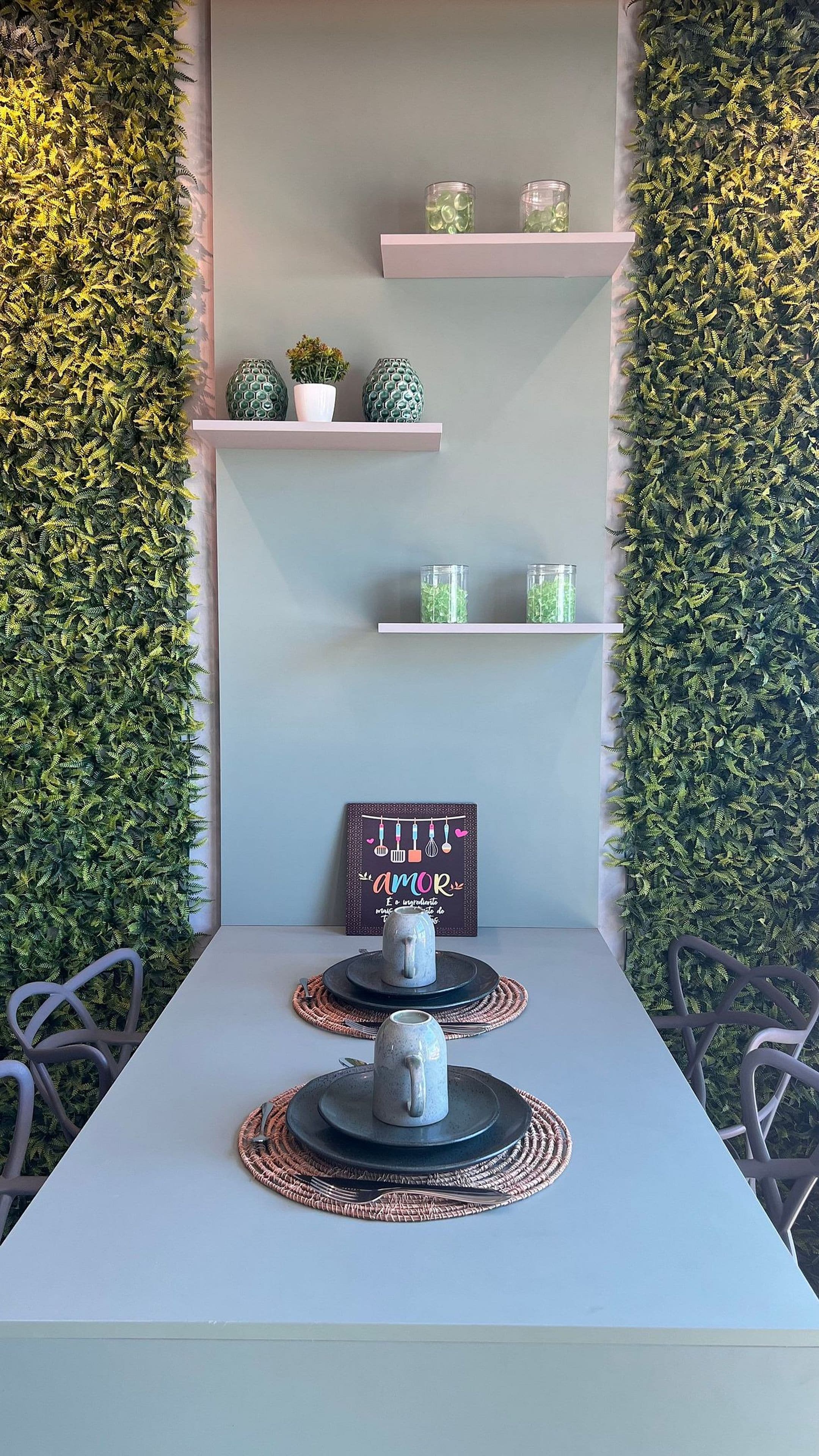 A dining area with a white table, two mugs, and a sign that reads "amor".