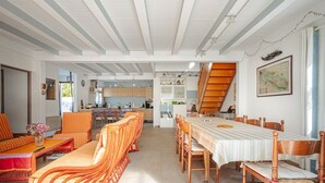 A spacious living area with a dining table, chairs, and a sofa.