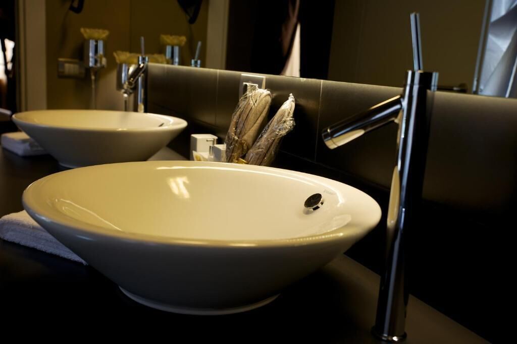A bathroom with two white sinks, a mirror, and a towel on the counter.