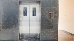 An elevator with a digital display, marble walls, and a plain interior. - Hotel Tanwar (Jaipur)