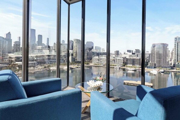 A modern room with a large window overlooking a cityscape and a river.