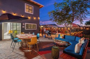 Un espace extérieur aménagé avec une terrasse, une table ronde, des chaises, un canapé et un barbecue.