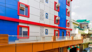 Un edificio de varios pisos con diseño moderno, que presenta una combinación de paneles azules y blancos con detalles en rojo.