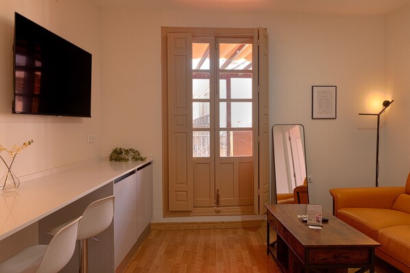 A compact living space with a kitchenette, a dining area, and a seating area with a sofa.