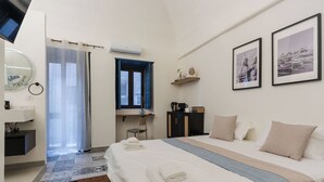 Habitación de hotel con cama, escritorio, silla, armario, espejo y ventana.