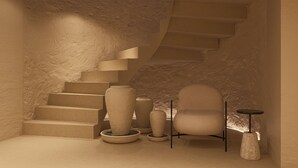 A staircase with a textured wall, a chair, and a small table. - F ZEEN ATHENS – Adults Only (Athens)
