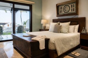 Une chambre à coucher avec un lit, une table de chevet, une lampe, une fenêtre et une vue sur l’extérieur.