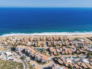 Un quartier résidentiel en bord de mer, avec des maisons, une plage et une vue dégagée sur l’océan.