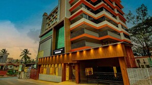 A multi-story building with a modern design, featuring a prominent chevron pattern on the facade. - Townhouse Oak Madgaon Railway Junction (Margao)