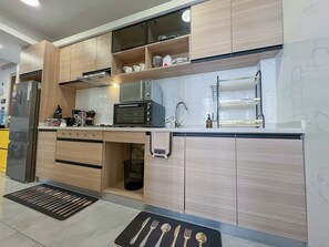 Een koelkast met diepvriezer, een microgolfoven, een oven, een kookplaat