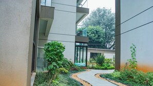 Un bâtiment moderne doté d’un chemin sinueux bordé de plantes et de petits galets.