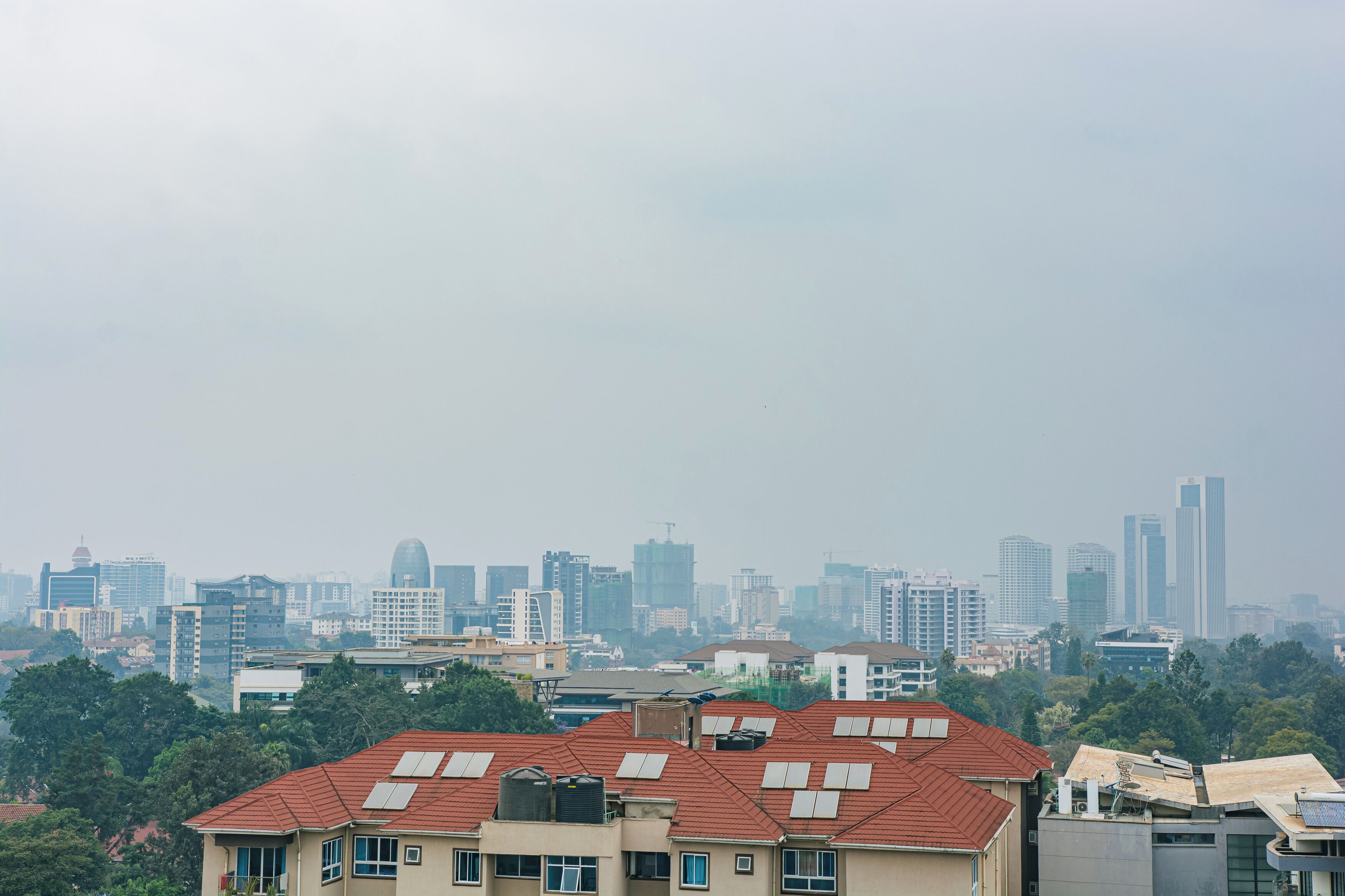 Une vue urbaine avec des gratte-ciel en arrière-plan et des immeubles résidentiels au premier plan.