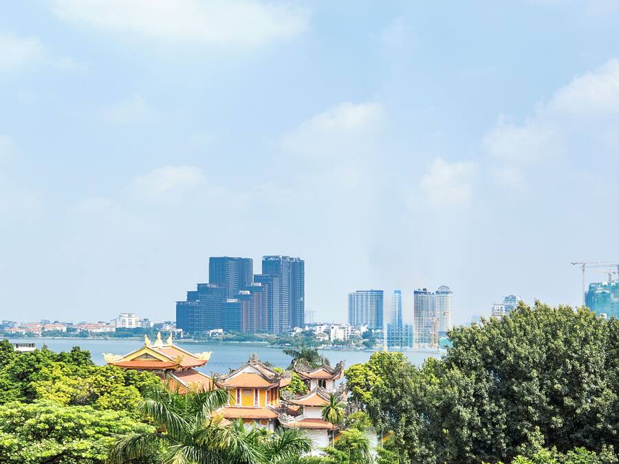 A cityscape with traditional architecture in the foreground and modern high-rise buildings in the background.