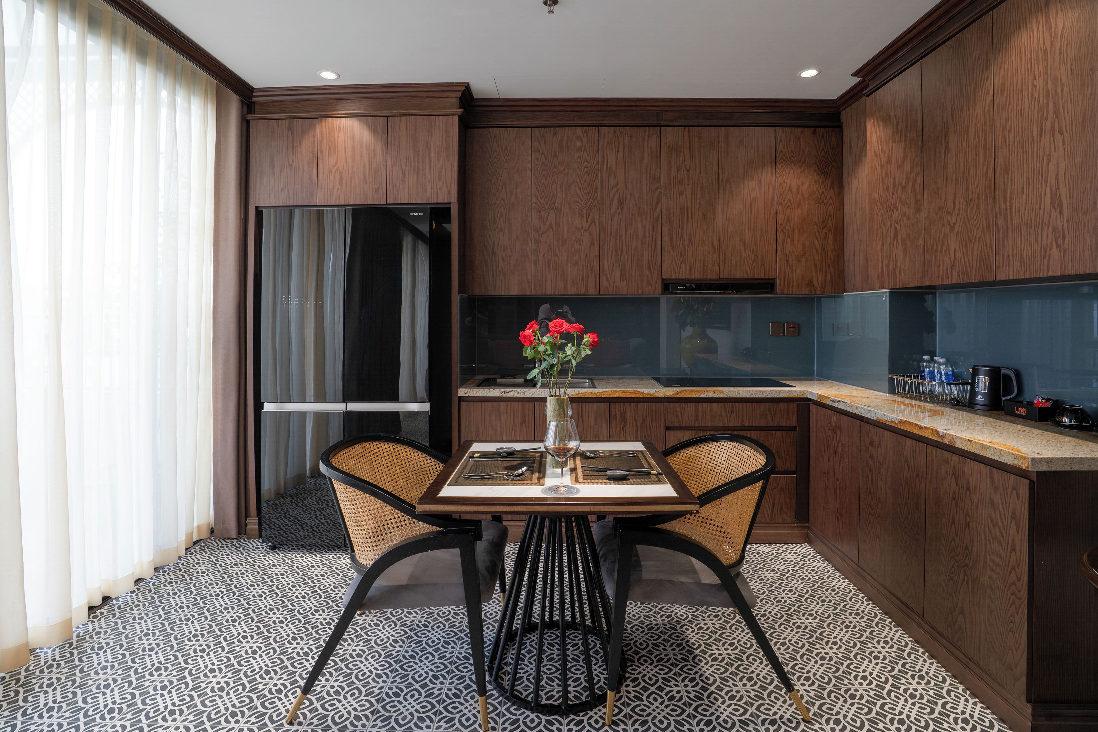 Una cocina moderna con una mesa de comedor, sillas y un florero con flores.