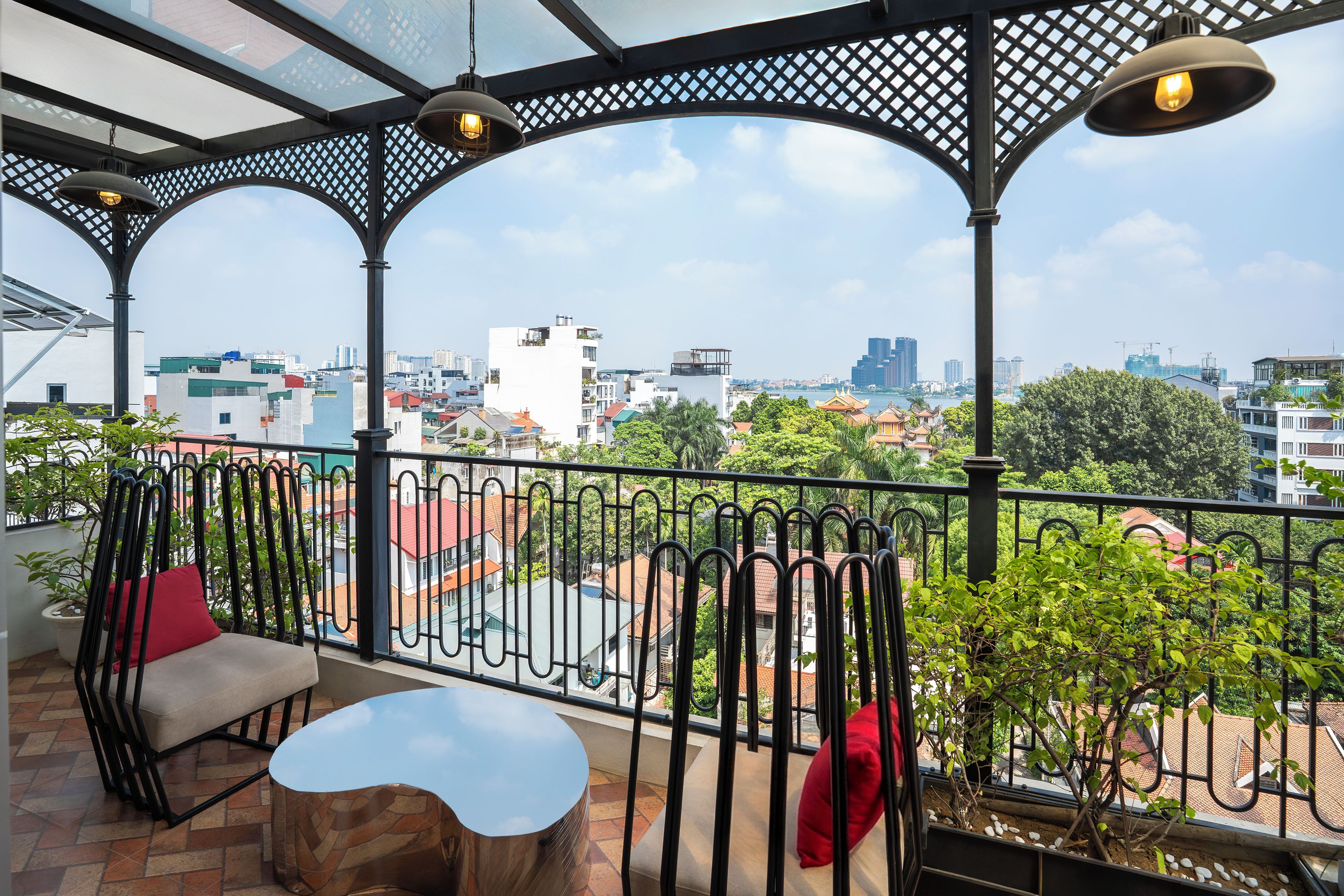 A balcony with a view of a cityscape, including buildings and a river.