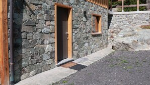A stone building with two wooden-framed doors and a small window.