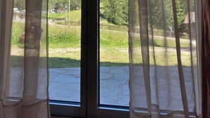 A room with a sliding glass door leading to a balcony with a mountain view.