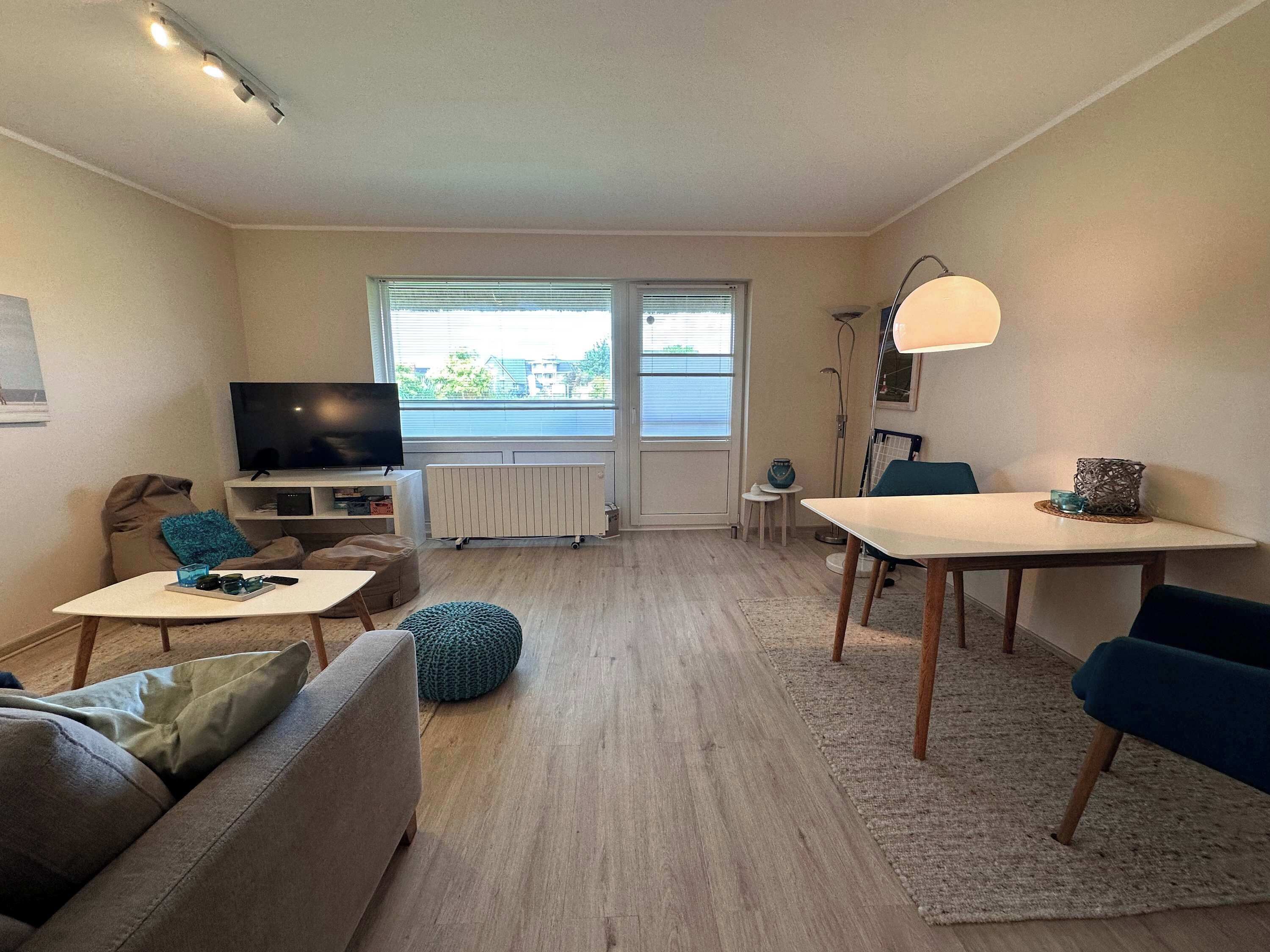 Een moderne woonkamer met een bank, een salontafel, een eettafel en een televisie.