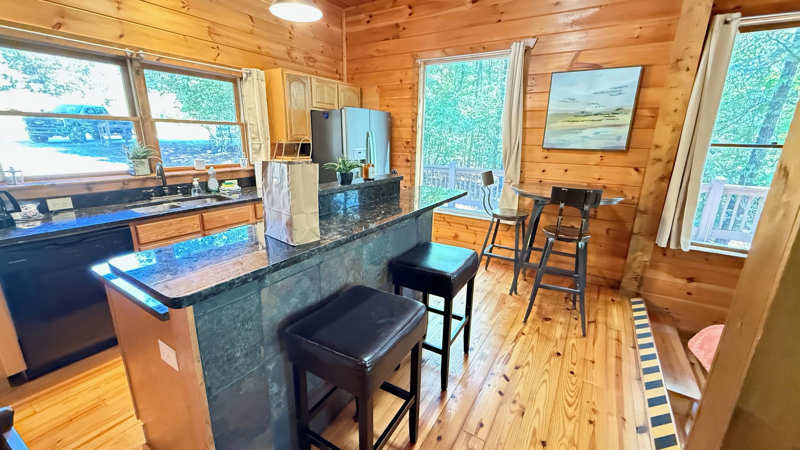 L’intérieur d’un chalet en bois comprend une cuisine, un coin bar et un espace salon.