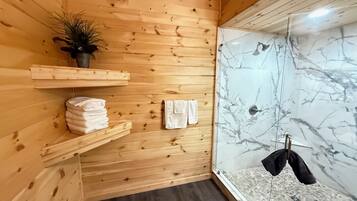A wooden interior with a shower area featuring marble walls.