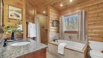 Un baño de cabaña de madera con lavabo, bañera y retrete.