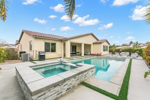 A residential property with a swimming pool, patio furniture, and a covered outdoor area. - Resort-Style Escape with Pool, Spa, BBQ & Fire Pit (La Quinta)