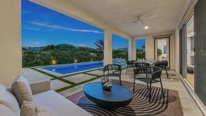 Un patio moderno al aire libre con piscina, zona de estar y vistas al paisaje.