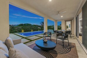 A modern outdoor patio with a pool, seating area, and a view of the landscape. - Resort-Style Escape with Pool, Spa, BBQ & Fire Pit (La Quinta)