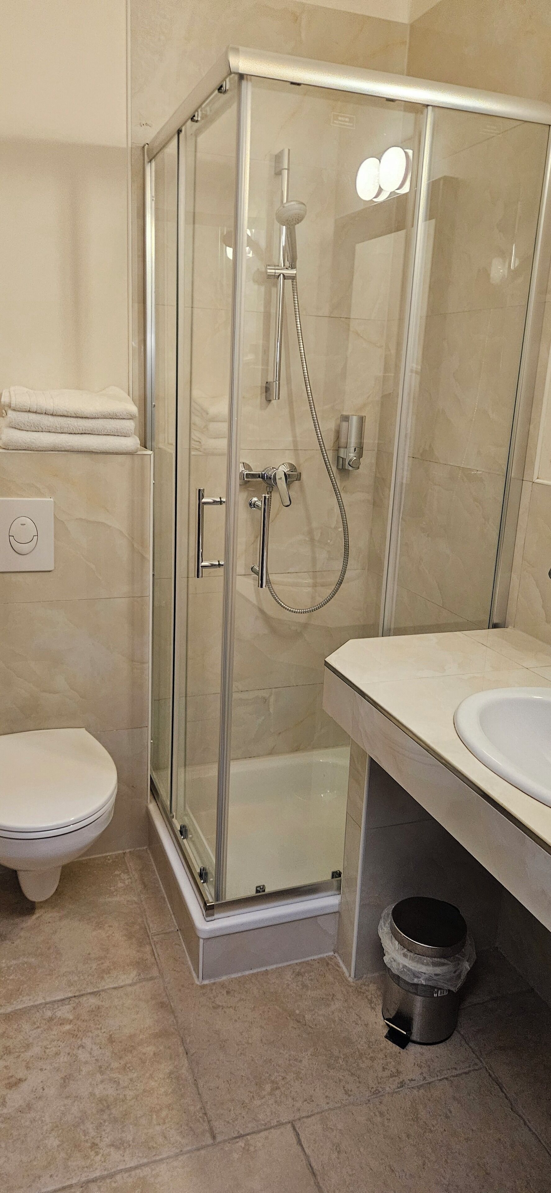 Un baño moderno con ducha de vidrio, inodoro y lavamanos.