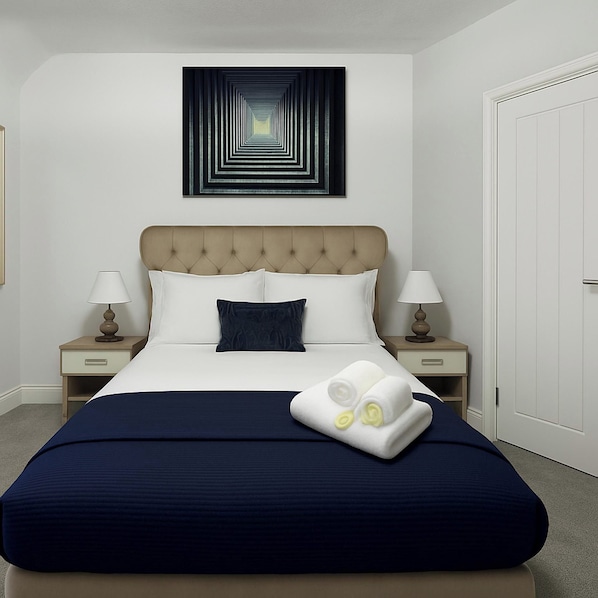 A hotel room with a large bed, two bedside tables with lamps, a wall art piece, and a door.
