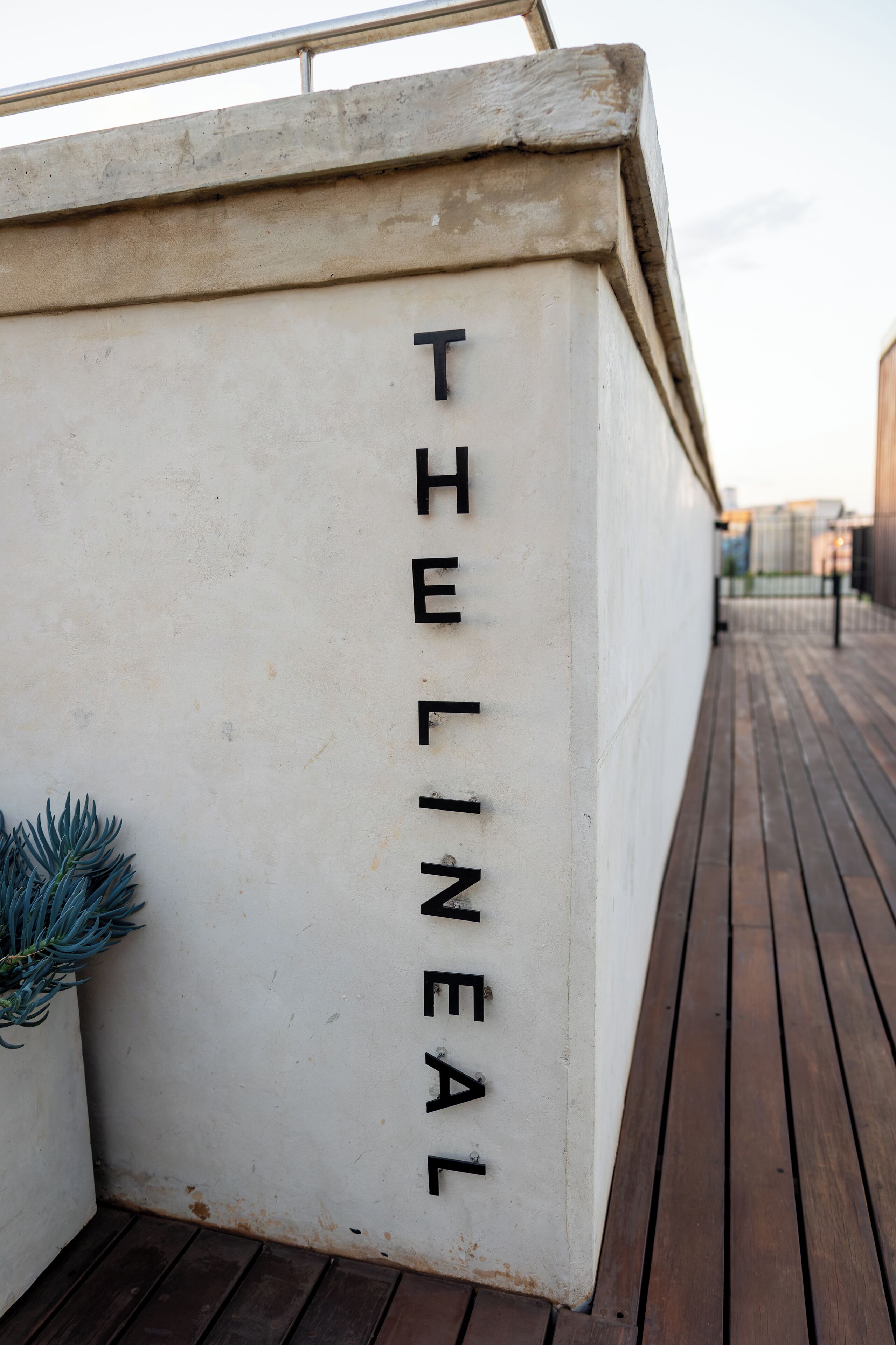Een witte muur met de woorden 'THE LINEAL' verticaal geplaatst.