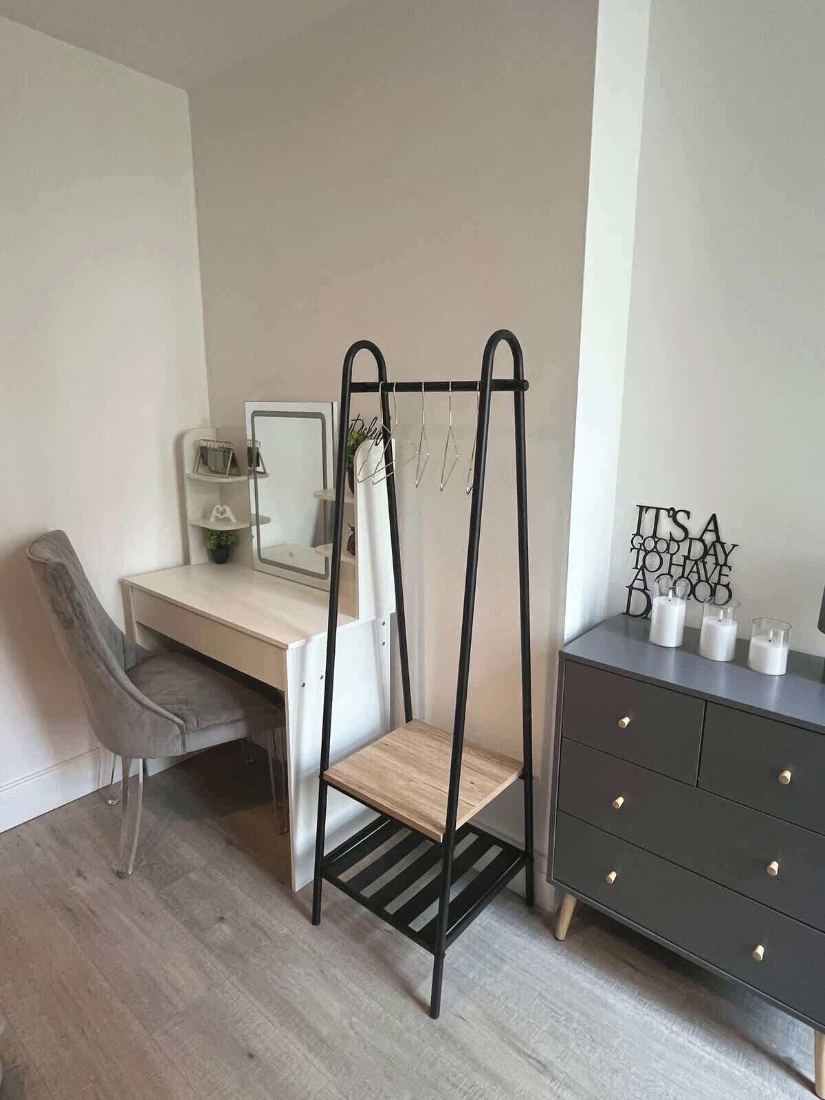 Ein modernes Schlafzimmer mit Schreibtisch, Stuhl und Kommode.