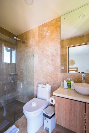 A modern bathroom with a glass-enclosed shower, a toilet, a sink, and a vanity. - Great views apartment with King bed Torres del Mar (Jacó, Torres del Mar)