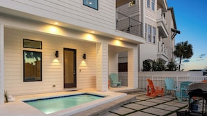 A two-story building with a covered patio area featuring a swimming pool, outdoor seating, and a gas cylinder. - NEW "Bikinis & Martinis" Private Pool,Gulf Views, Bikes, LSV (Santa Rosa Beach)