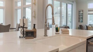 A modern kitchen with a large sink, a decorative towel dispenser, and a bottle of soap. - NEW "Bikinis & Martinis" Private Pool,Gulf Views, Bikes, LSV (Santa Rosa Beach)