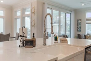 A modern kitchen with a large sink, a decorative towel dispenser, and a bottle of soap. - NEW "Bikinis & Martinis" Private Pool,Gulf Views, Bikes, LSV (Santa Rosa Beach)