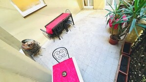 A courtyard with a table and chairs, potted plants, and a metal chair. - La Dimora di Sara - Comfort and Privacy at 10 Minutes from Termini (Roma)