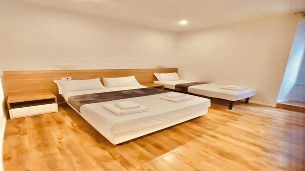 A modern hotel room with a large bed, bedside tables, and a wooden floor. - La Dimora di Sara - Comfort and Privacy at 10 Minutes from Termini (Roma)