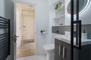 A modern bathroom with a toilet, sink, and mirror. - Jackson Terrace HL6 - Grampian Lettings (Aberdeen)