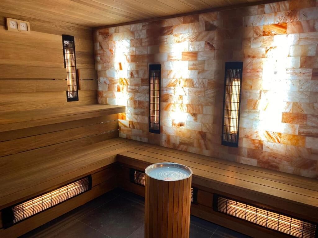 Una sauna con bancos de madera y paredes de piedra.