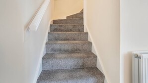 Eine Treppe mit Teppichstufen und weißen Wänden.
