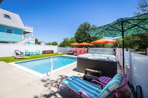 A backyard with a swimming pool, hot tub, lounge chairs, and umbrellas. - This Home Has It All! Location, Amenities, & More! (Duck)