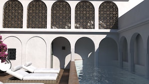 Una piscina al aire libre, sombrillas, sillones reclinables de piscina
