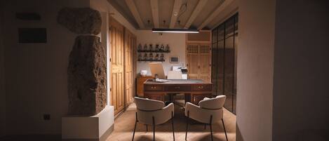 A modern kitchen with wooden cabinets, a stone accent wall, and a dining area with two chairs.